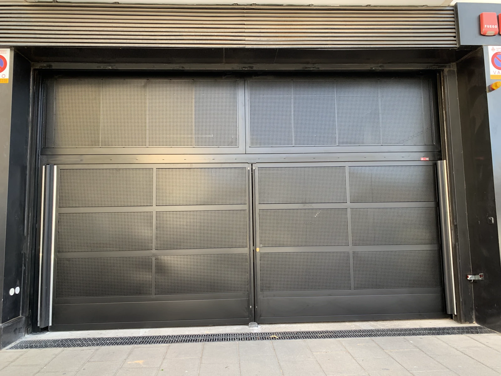 Puerta abatible automática negra de garaje instalada