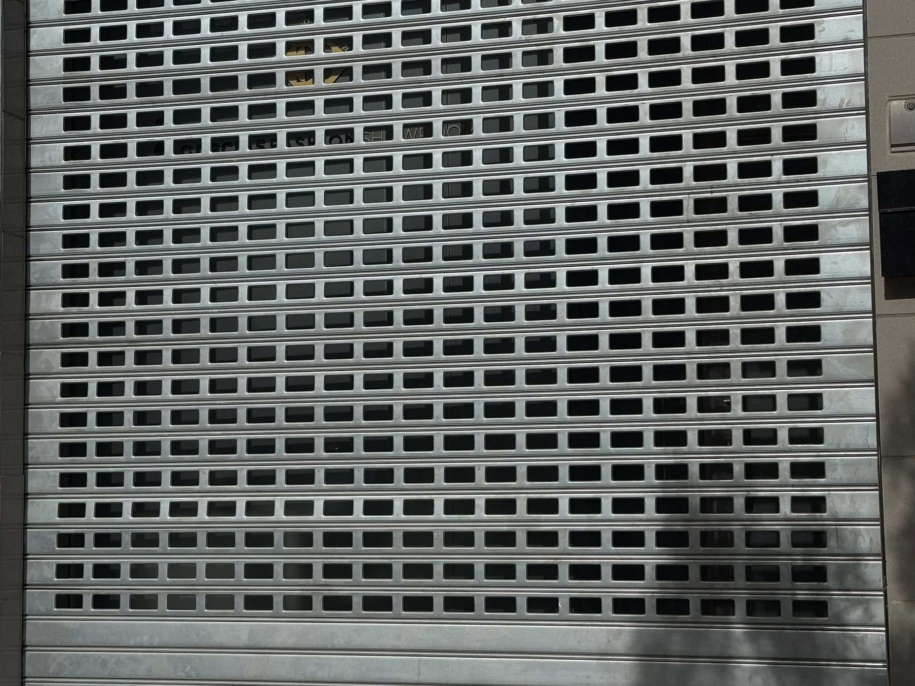 Vista frontal de una puerta enrollable galvanizada troquelada