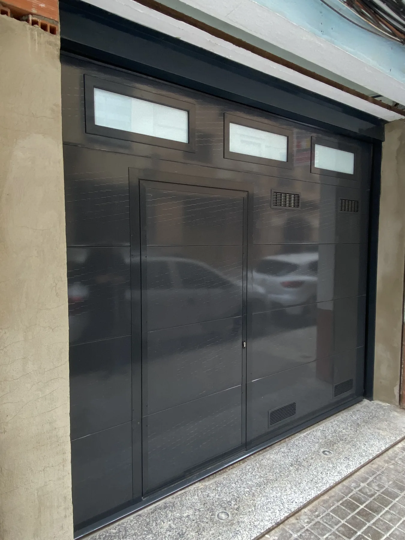 Puerta seccional de garaje con paneles de cristal